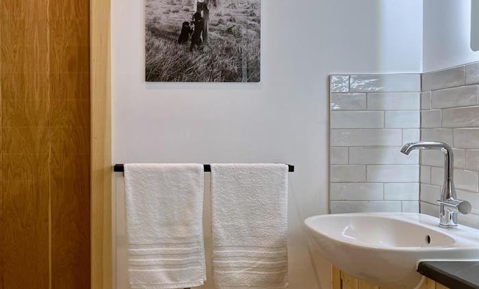 The shower room is bright and clean with tiling around the basin and natural slate surfaces